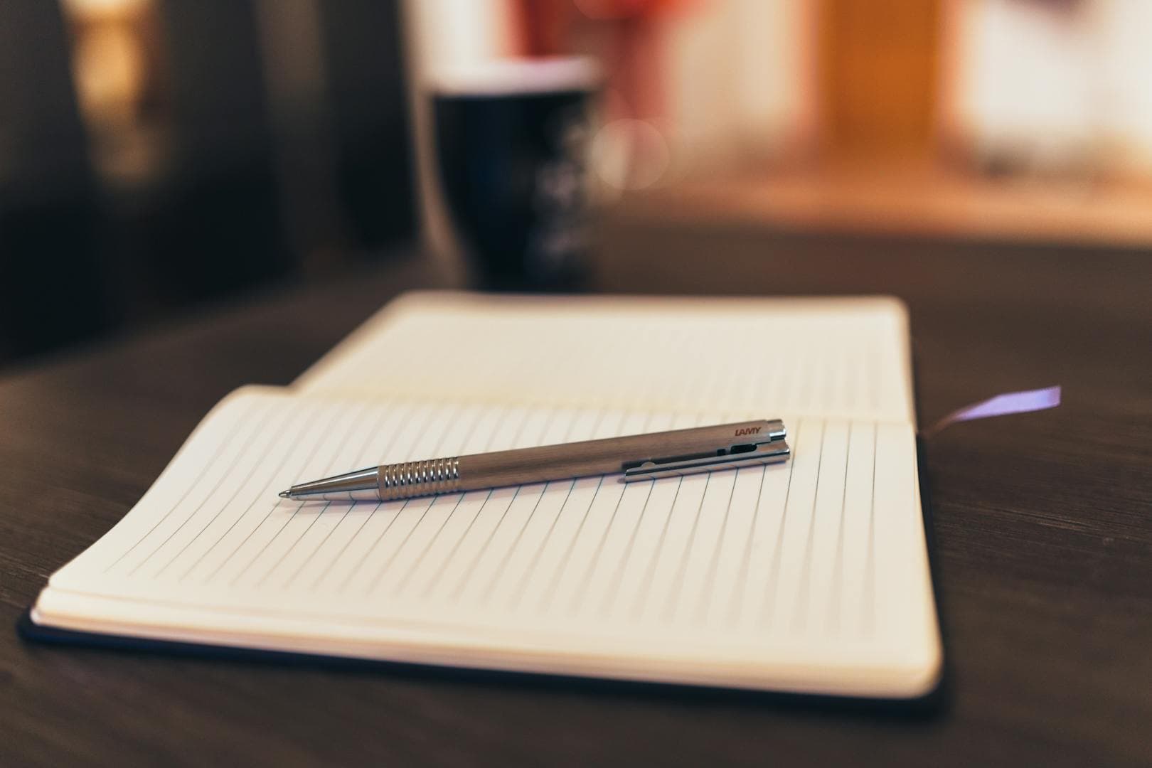 An open lined notebook with a pen resting on it, ready for planning